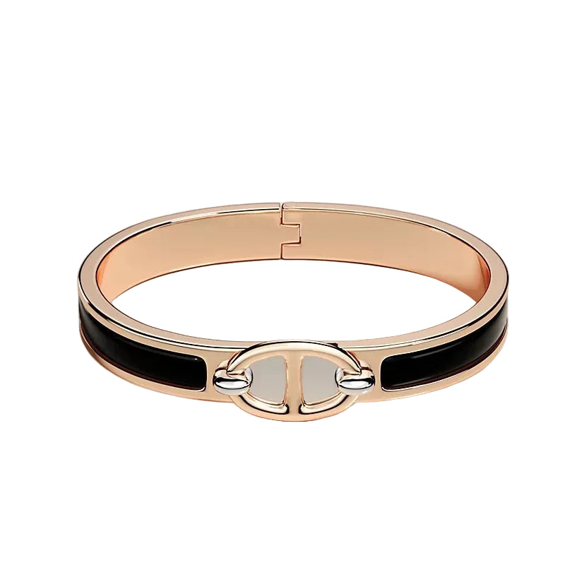 Rose gold bracelet with black accents on a light beige background
