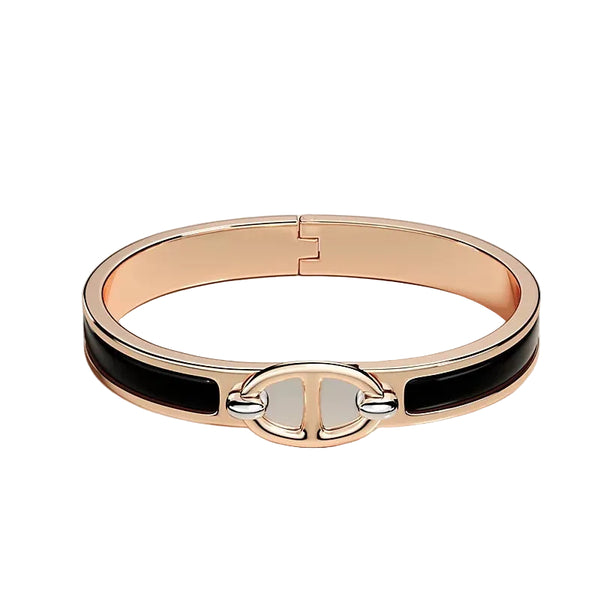 Rose gold bracelet with black accents on a light beige background